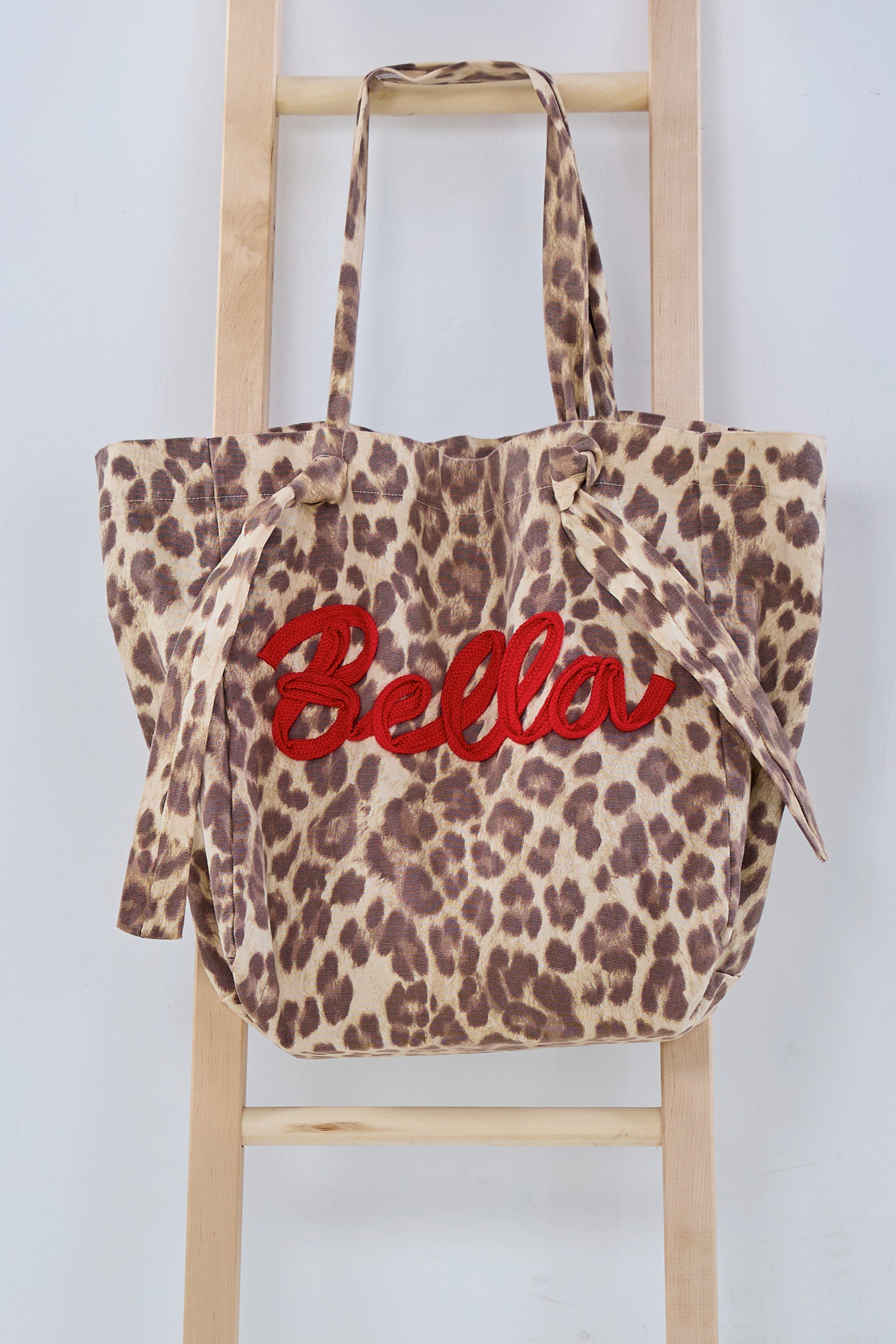 Shopper mit aufgenähtem Schriftzug: Bella in leo Optik, beige-braun-rot
