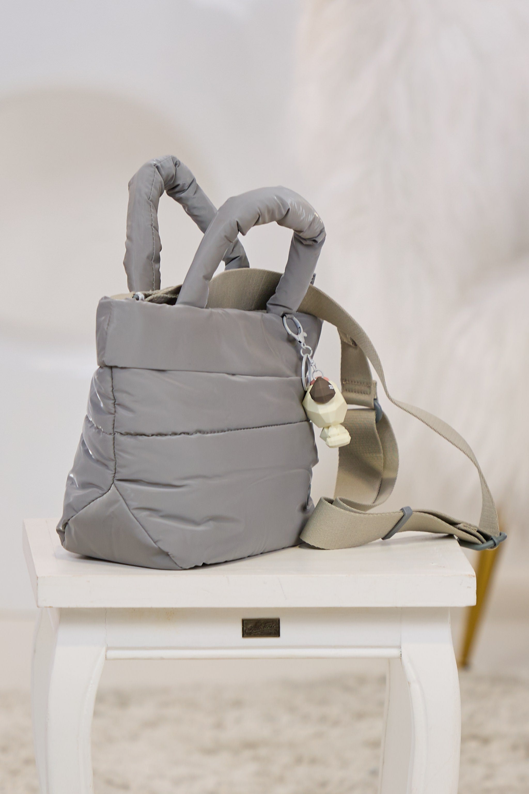 Henkeltasche mit Anhänger, grau-glänzend