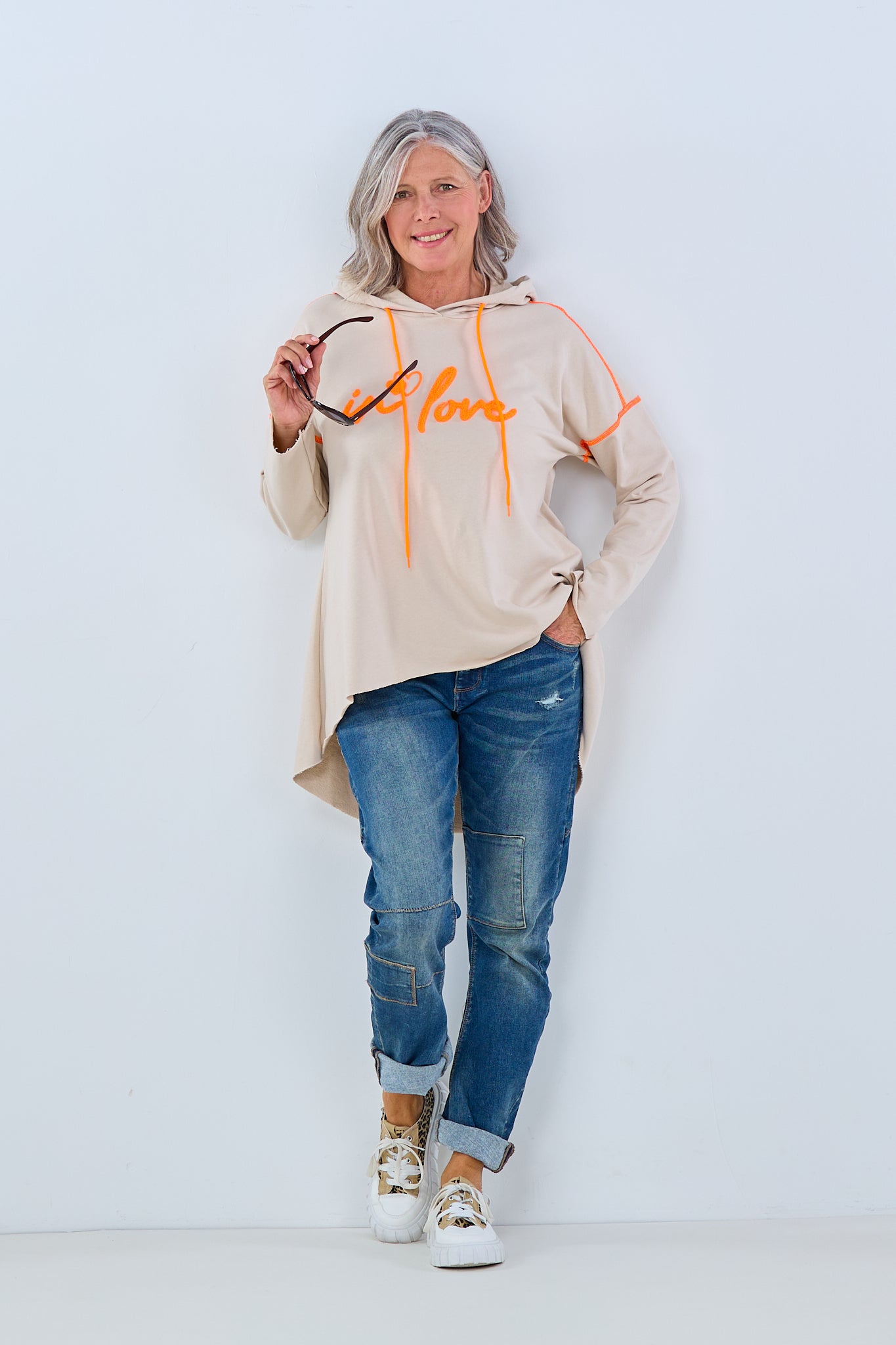 beigefarbener Hoodie mit aufgeflocktem Schriftzug in orange von Trends & Lifestyle