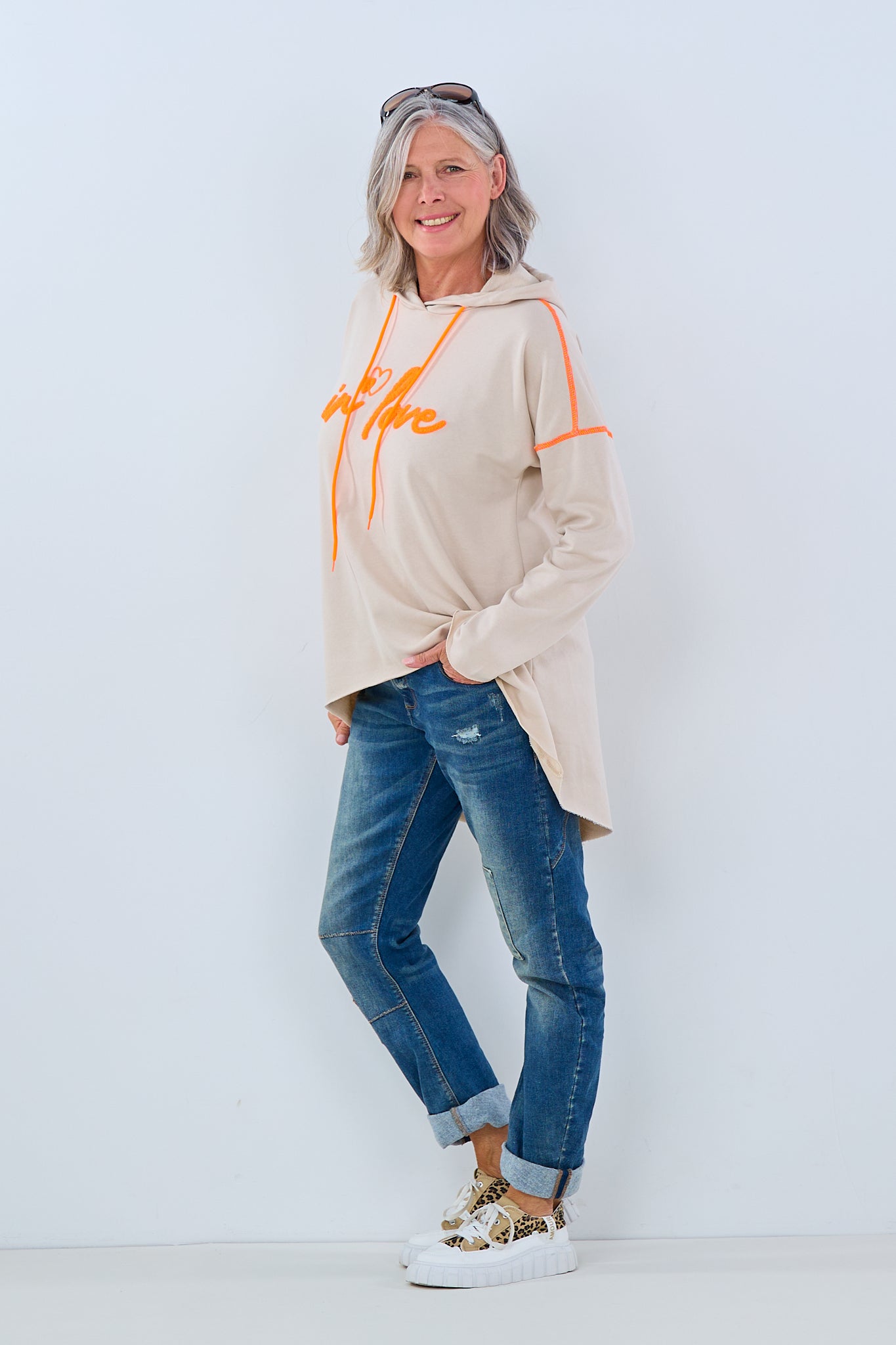 beigefarbener Hoodie mit aufgeflocktem Schriftzug in orange von Trends & Lifestyle