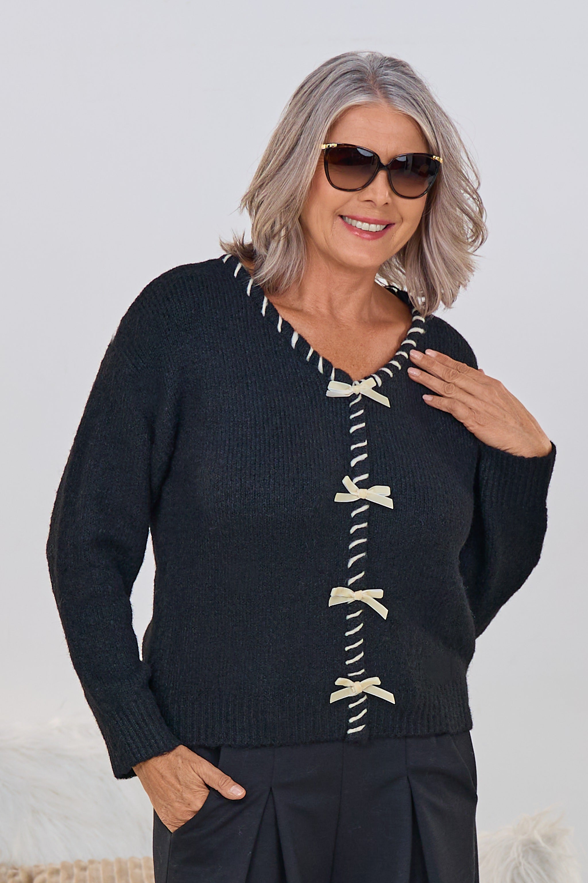 Strickpulli mit V-Ausschnitt und Schleifen, schwarz-ecru