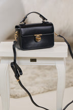 elegante Tasche mit Drehverschluss, schwarz-gold